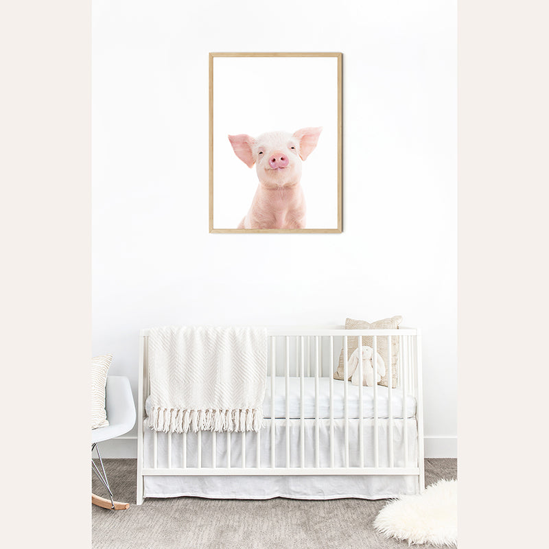 a picture of a pig hanging on a wall above a crib