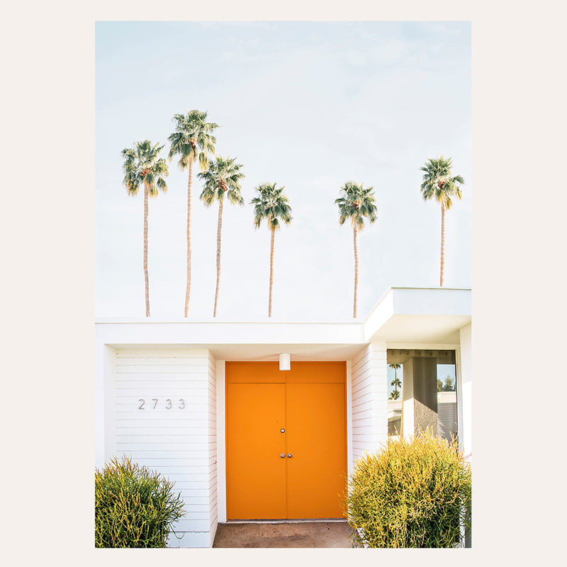 an orange door is in front of a white house