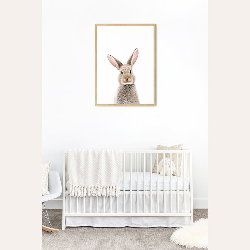 a baby&#39;s room with a white crib and a picture of a rabbit