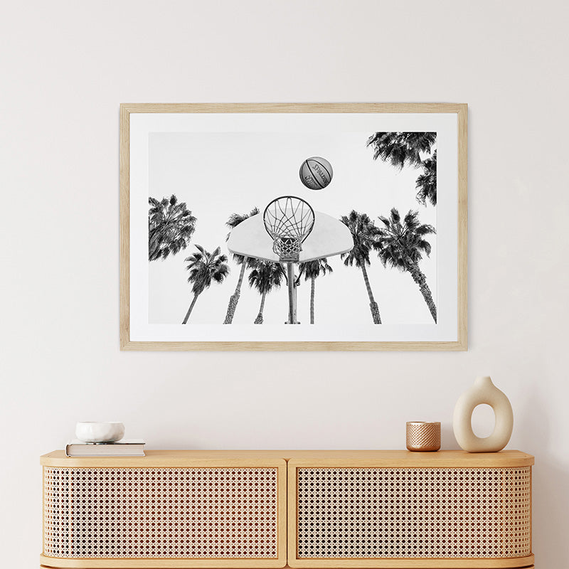 a black and white photo of a basketball hoop and palm trees