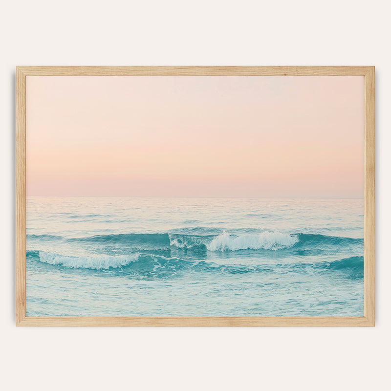 a picture of the ocean with a pink sky in the background