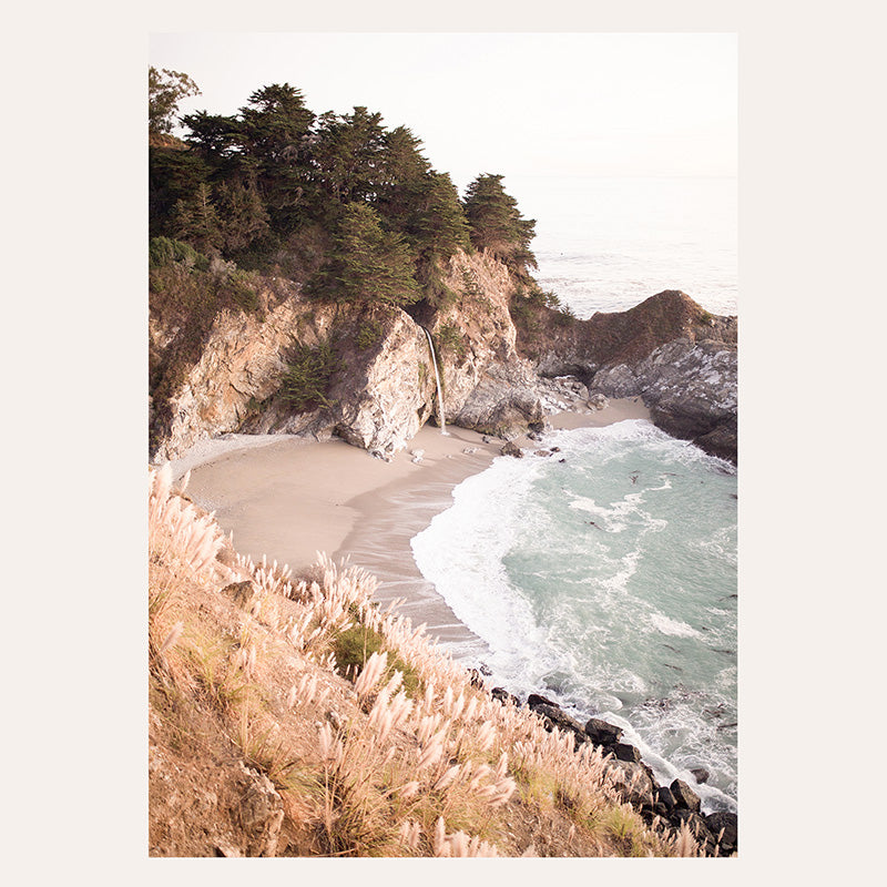 a picture of a beach with a cliff in the background