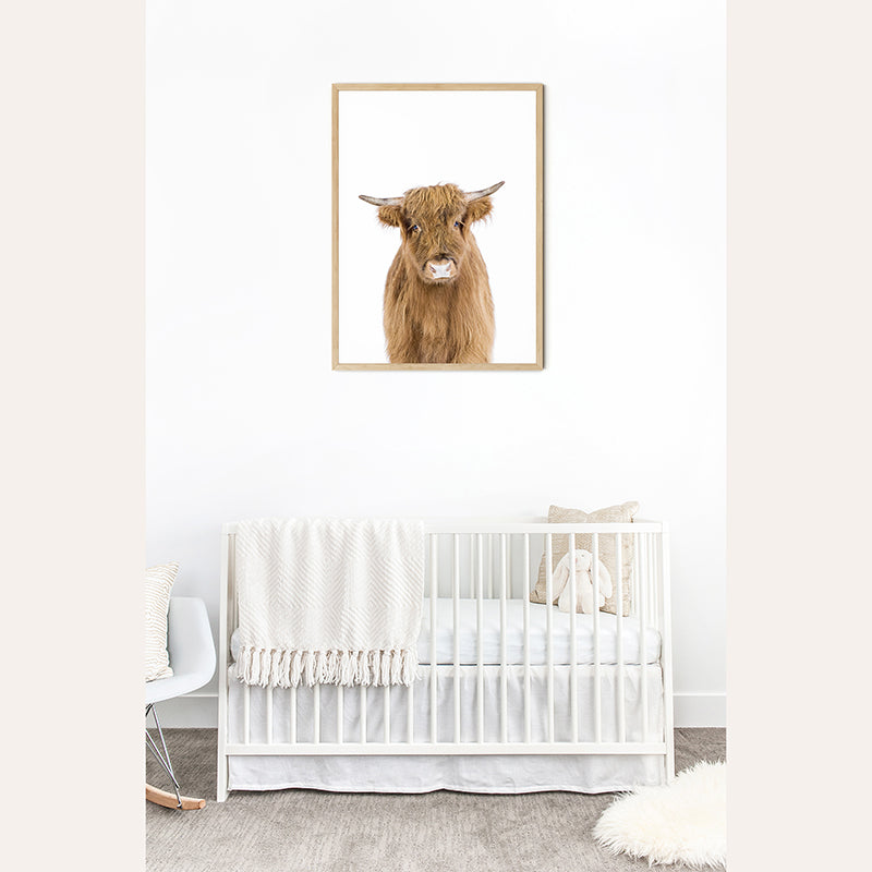 a baby&#39;s room with a white crib and a picture of a cow