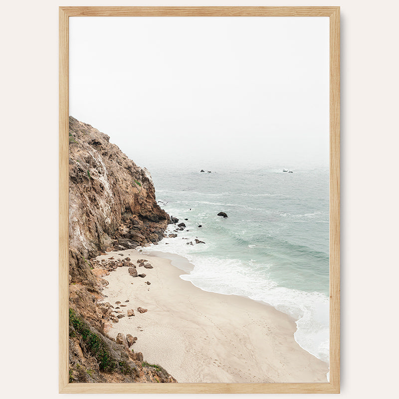 a picture of a beach with a cliff in the background