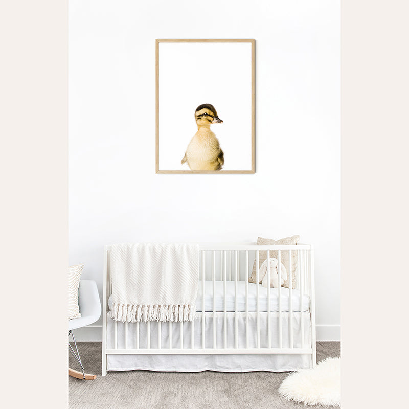 a baby&#39;s room with a white crib and a picture of a duck