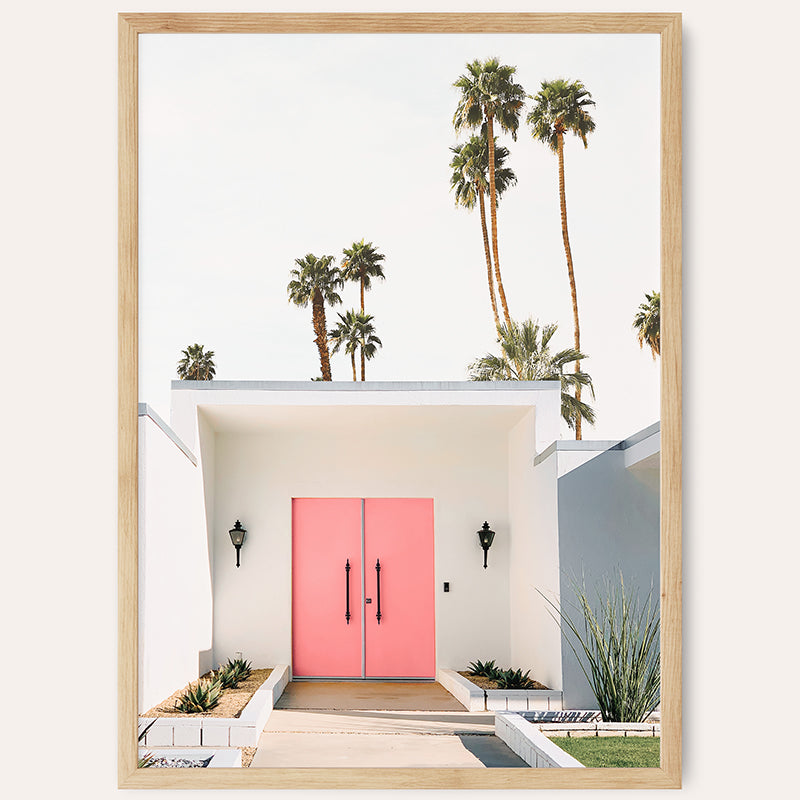 a pink door in front of a white house