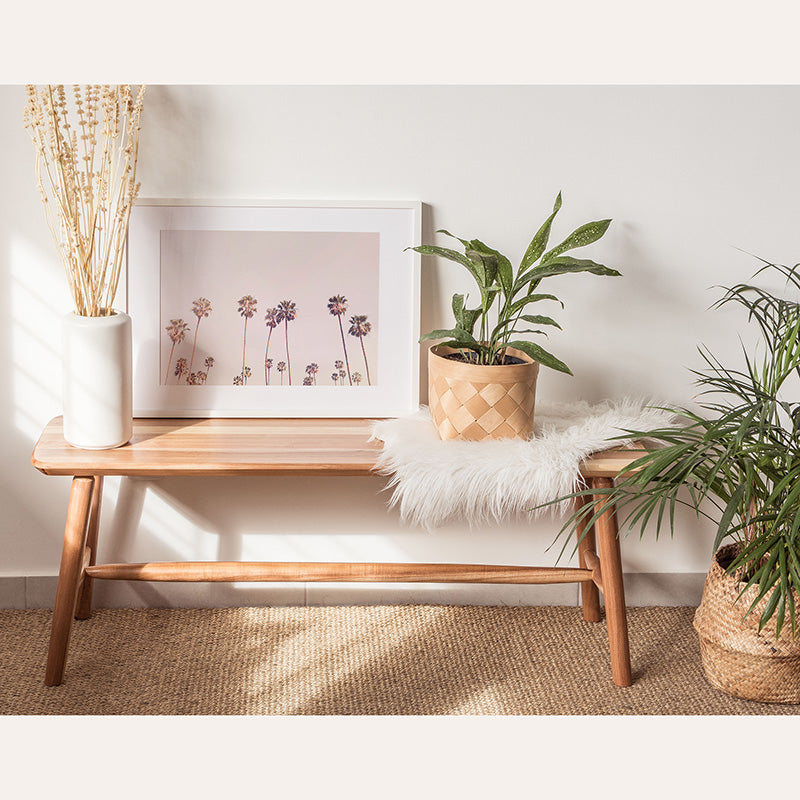 a wooden bench sitting next to a potted plant