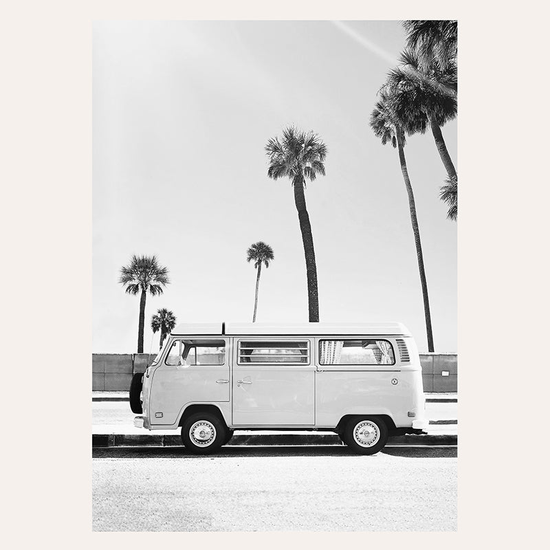 a black and white photo of a vw bus parked in front of palm trees