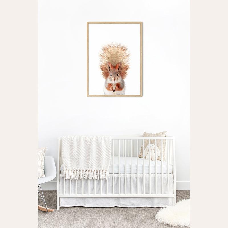 a baby&#39;s room with a white crib and a picture of a squirrel