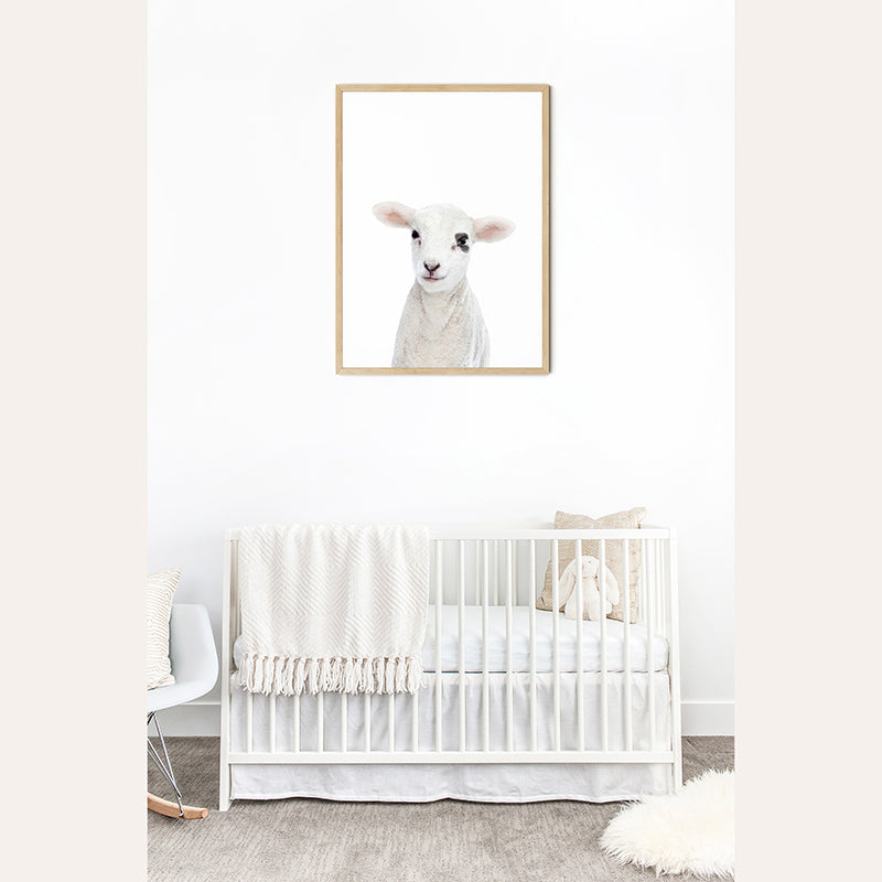 a baby&#39;s room with a white crib and a picture of a sheep