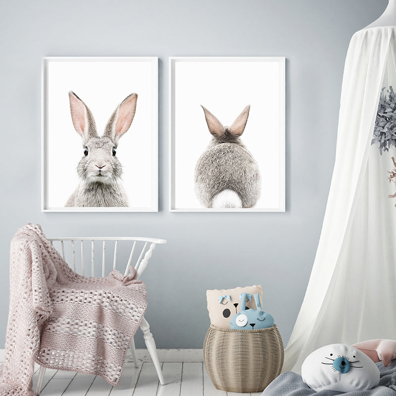 a baby&#39;s room with two pictures of rabbits on the wall