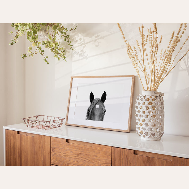 a picture of a horse on a shelf next to a vase