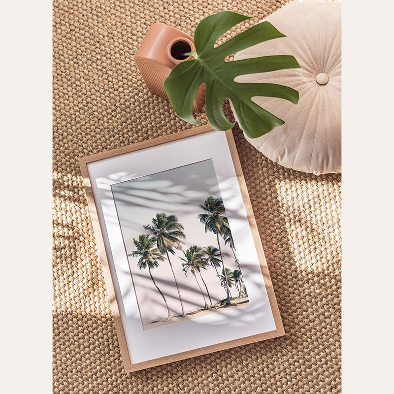 a picture of a palm tree in a frame next to a potted plant