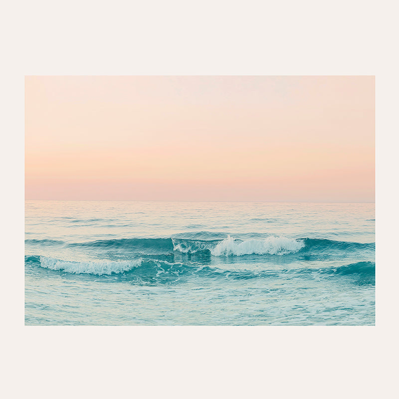 a picture of the ocean with a pink sky in the background