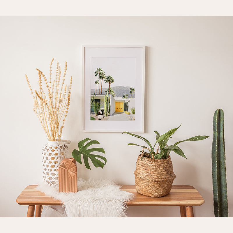 a wooden table topped with two potted plants