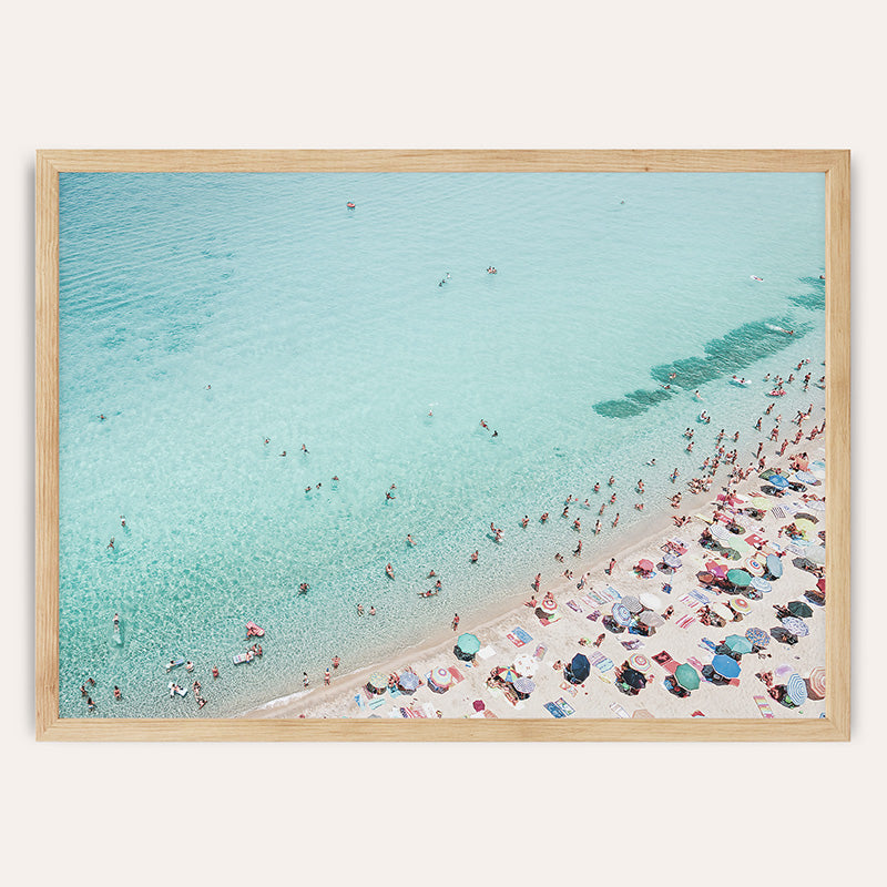 an aerial view of a crowded beach with people in the water