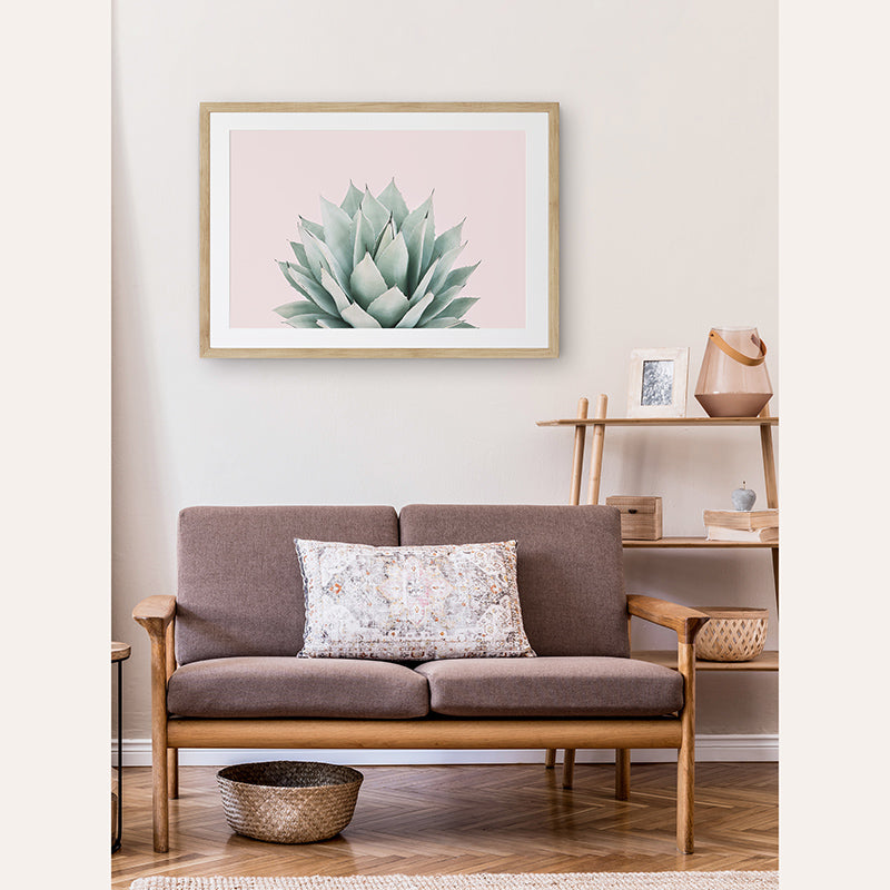 a picture of a living room with a couch and a plant on the wall