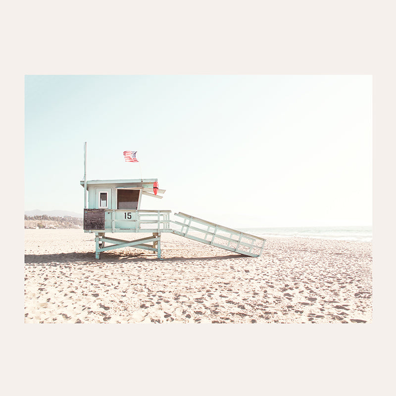 a lifeguard stand on the beach with a flag on top