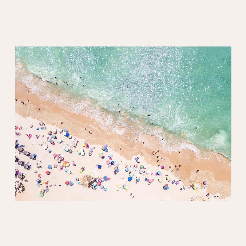 an aerial view of a beach with people and umbrellas