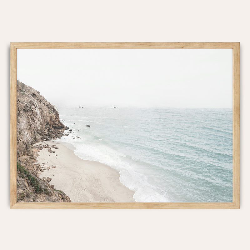 a picture of a beach with a cliff in the background