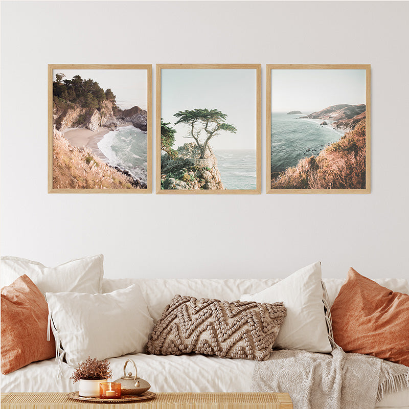 a living room with a couch and three paintings on the wall