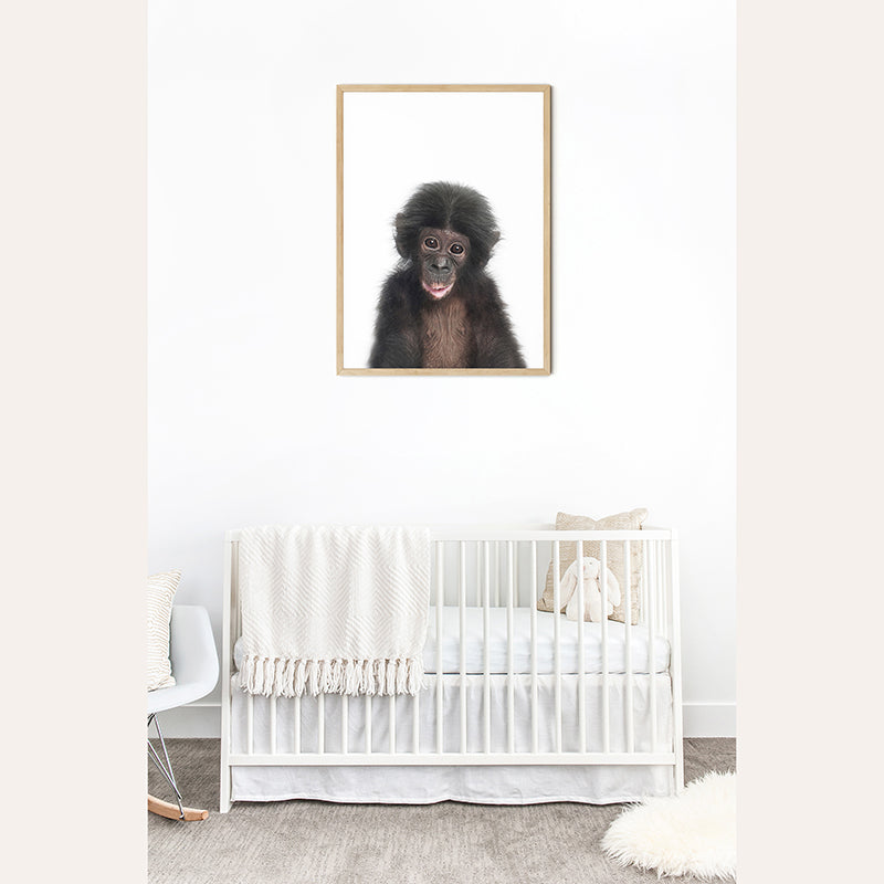 a baby monkey hanging on a wall next to a crib